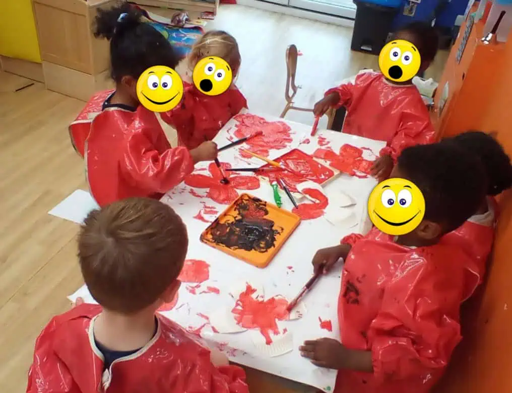 Colorful preschool children engaging in a creative painting activity at Monkey Puzzle Day Nursery Enfield, promoting early childhood development and artistic expression in a safe, nurturing environment.