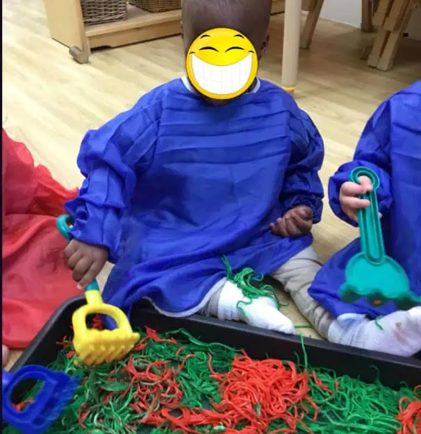 Colorful rubber band play activity at Monkey Puzzle Day Nursery Enfield, encouraging sensory and fine motor skills in preschool children.