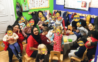 Friendly children and staff enjoying a fun group activity at Monkey Puzzle Day Nursery Enfield, with vibrant classroom decor and a warm, welcoming atmosphere for early childhood learning and development.