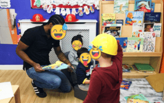 Brightly decorated children’s reading area at Monkey Puzzle Day Nursery Enfield with kids and caregiver engaging in storytime.