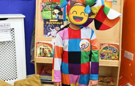 Colorful clown costume worn by child at Monkey Puzzle Day Nursery Enfield, fostering imaginative play and early childhood development.