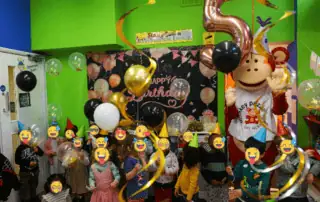 1_66860 Colorful kids birthday celebration at Monkey Puzzle Day Nursery Enfield with balloons and party decorations in a vibrant indoor setting.