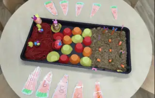 easter maths activity Carrot-themed sensory and STEM activity tray for preschool children at Monkey Puzzle Day Nursery Enfield. Includes colorful cupcake liners, toy carrots, and doodle carrots for interactive learning and play.