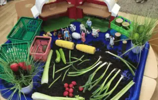 Learning about vegetables Fresh vegetable and farm animal sensory play area at Monkey Puzzle Day Nursery Enfield, engaging outdoor learning space for early childhood development and education in a nurturing environment.