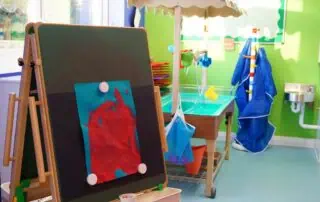 nursery art and wet play area Colorful indoor nursery environment with art supplies, play area, and bright green walls at Monkey Puzzle Day Nursery Enfield, promoting playful learning and child development.