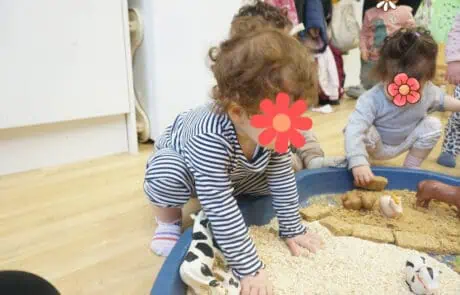 Children playing in sensory sand tray at Monkey Puzzle Day Nursery Enfield, a nurturing and stimulating early childhood education setting for kids.