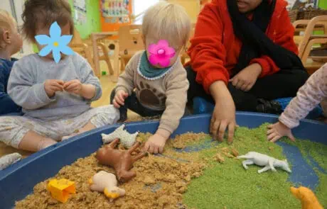 Children playing with animal figurines and sand at Monkey Puzzle Day Nursery Enfield, fostering imaginative learning and sensory development.