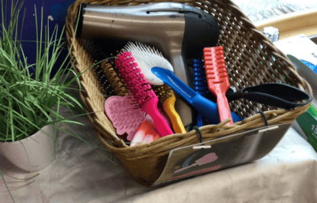 Hairbrush and grooming tools in a wicker basket in a childcare setting.
