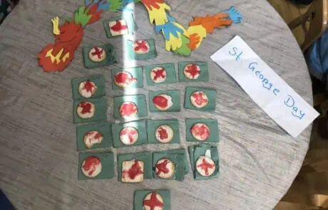 Colorful dragon craft and cookie badges for St. George's Day celebration at Monkey Puzzle Day Nursery Enfield.