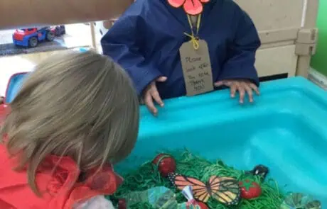 Flowers on child's chest with a note that reads "Please look after this bear".