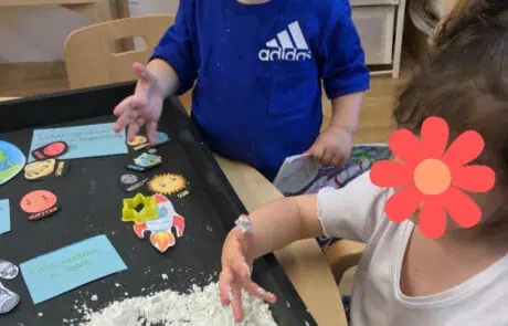 Brightly colored toys andEducational play activities at Monkey Puzzle Day Nursery Enfield play area with children engaging with sensory sand and educational materials.
