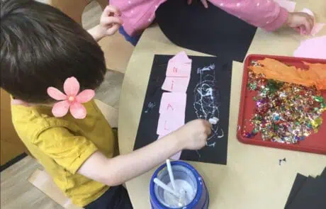 Colorful children's craft activities at Monkey Puzzle Day Nursery Enfield, including paper decorating, glitter, and creative arts for early childhood development.