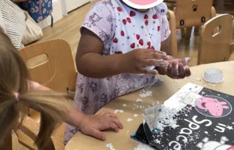 Building block activity at Monkey Puzzle Day Nursery Enfield, children playing with snow, engaging in sensory play, early childhood development, indoor preschool classroom, happy kids exploring textures, nursery learning environment, early education center, fun interactive activities for children, vibrant nursery setting.