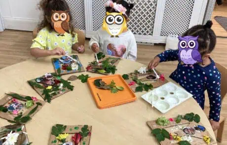 Colorful children's craft activity with natural leaves, flowers, and photos at Monkey Puzzle Day Nursery Enfield, fostering creativity and sensory exploration for early learners.