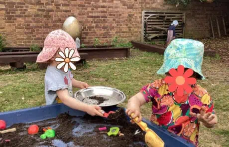 Children playing with soil and gardening tools at Monkey Puzzle Day Nursery Enfield, engaging in outdoor creative and sensory activities.