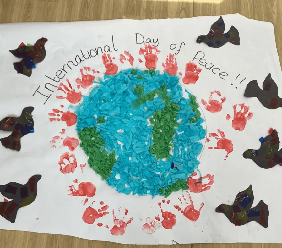 Earth Day artwork with painted hand prints and paper butterflies, celebrating peace and environmental awareness at Monkey Puzzle Day Nursery Enfield.