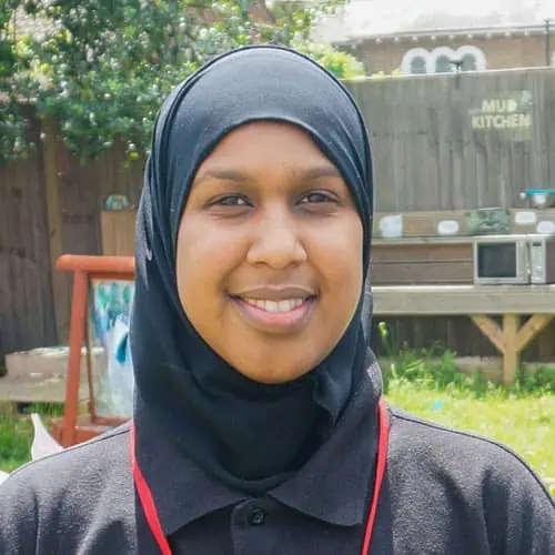 Bright smiling nursery staff member at Monkey Puzzle Day Nursery Enfield, showcasing a caring environment for children.