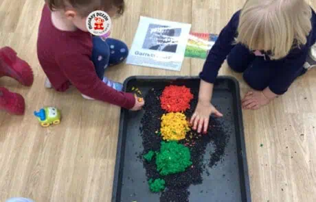 Flower-shaped sensory play with colorful grains at Monkey Puzzle Day Nursery Enfield, fostering early childhood development and messy play activities for preschool children.