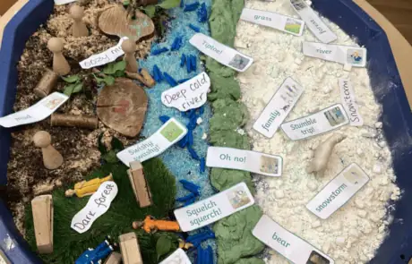 Cave-themed sensory play area with miniatures and labels for nature exploration, suitable for early childhood education at Monkey Puzzle Day Nursery Enfield.