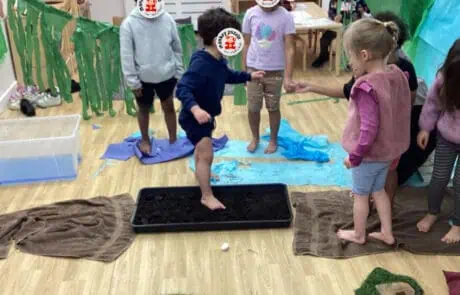 Sun-safe outdoor activity for preschool children at Monkey Puzzle Day Nursery Enfield, engaging kids in sensory and water play with colorful props and children having fun together.