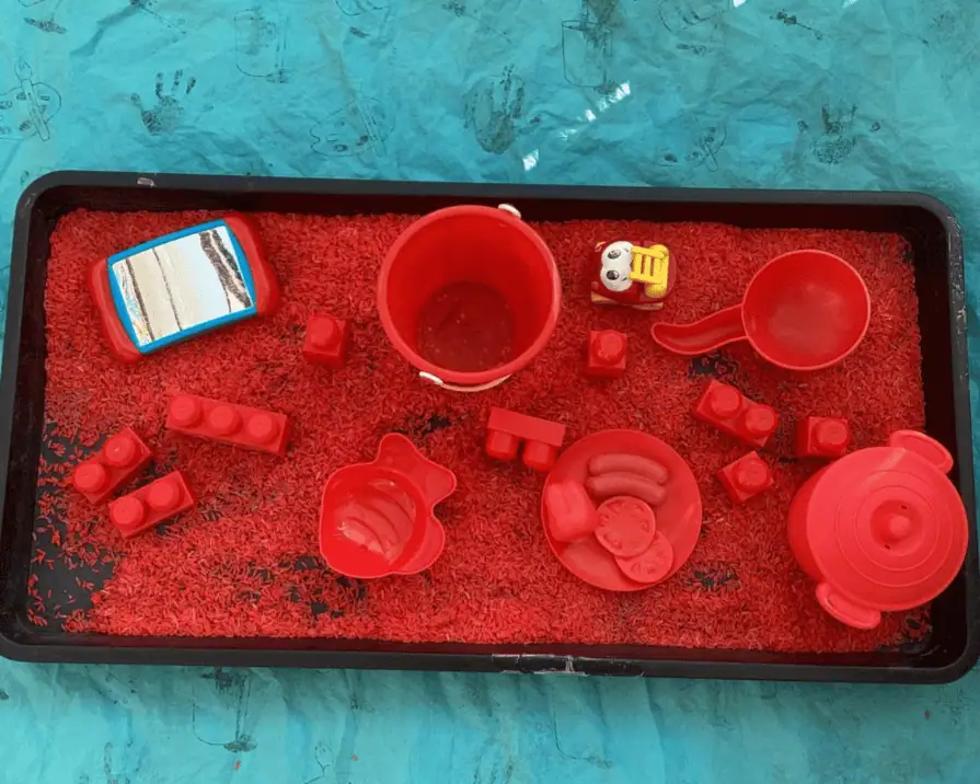 Colorful Red Play Kitchen Toys for Kids at Monkey Puzzle Day Nursery Enfield, encouraging imaginative play and early development skills.