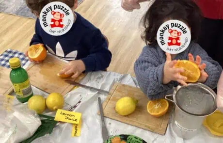 Brightly colored lemons and oranges on a table at Monkey Puzzle Day Nursery Enfield, where children are engaged in a hands-on fruit tasting activity.