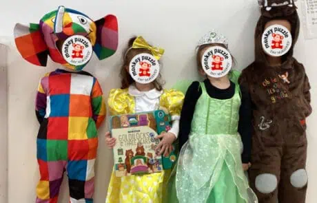 Colorful clown costume and children dressed as princesses and a bear for Monkey Puzzle Day Nursery Enfield celebration. Fun, engaging nursery activity with children in costumes.