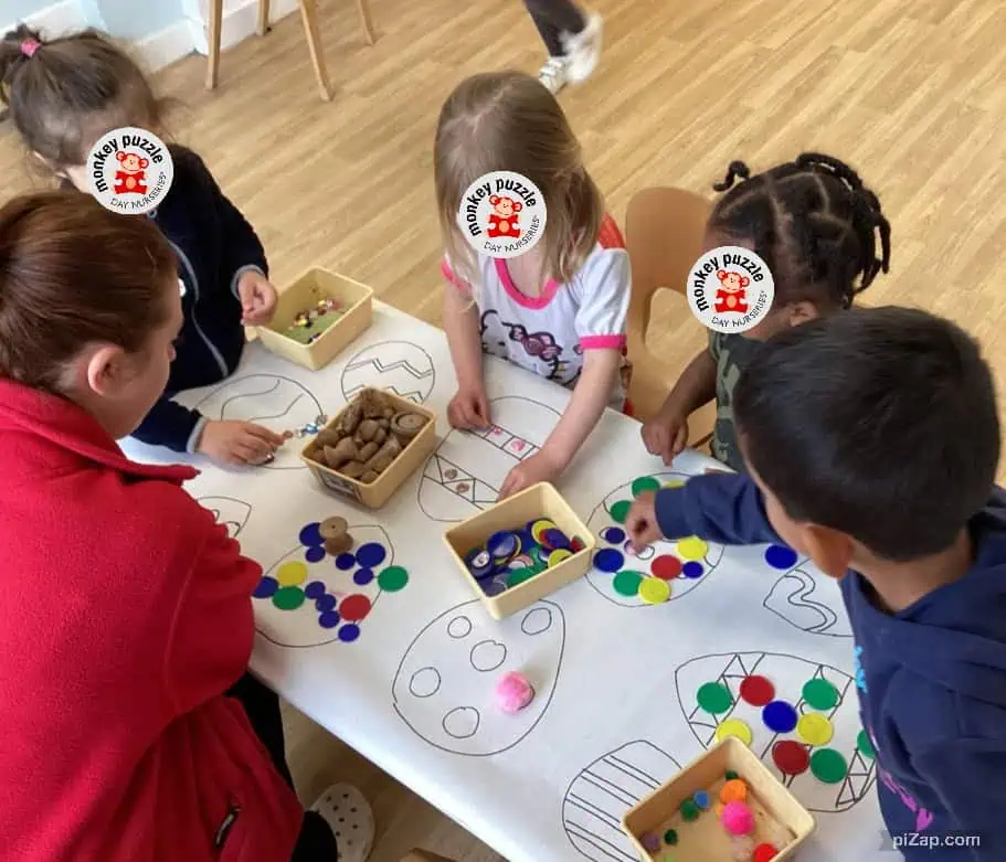 Monkey Puzzle Day Nursery Enfield children engaging in a colorful Easter-themed craft activity with various decorations and stickers.