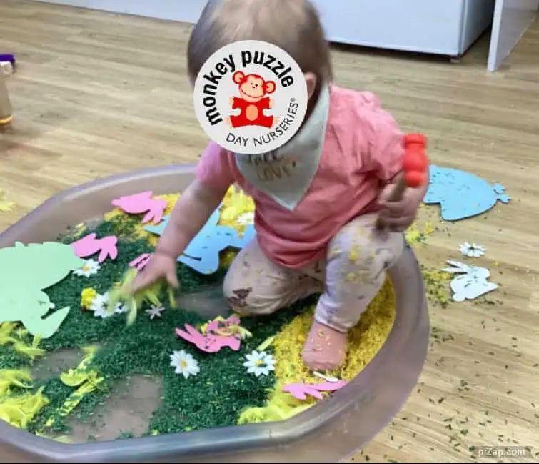 Colorful sensory play activity at Monkey Puzzle Day Nursery Enfield with a young child exploring various textures and educational toys.