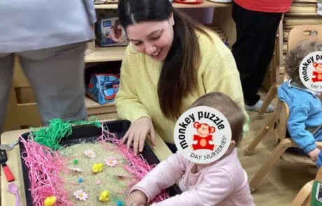 Colorful Easter-themed sensory activity with young children and teacher at Monkey Puzzle Day Nursery Enfield.