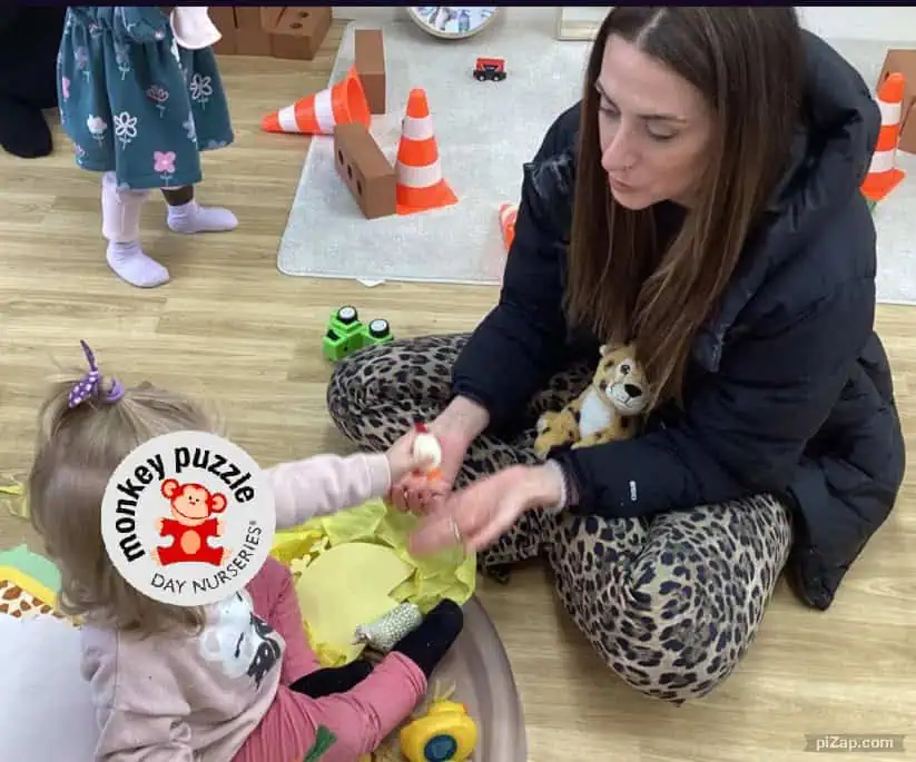 Colorful indoor play area at Monkey Puzzle Day Nursery Enfield with children engaging in activities and a caregiver.