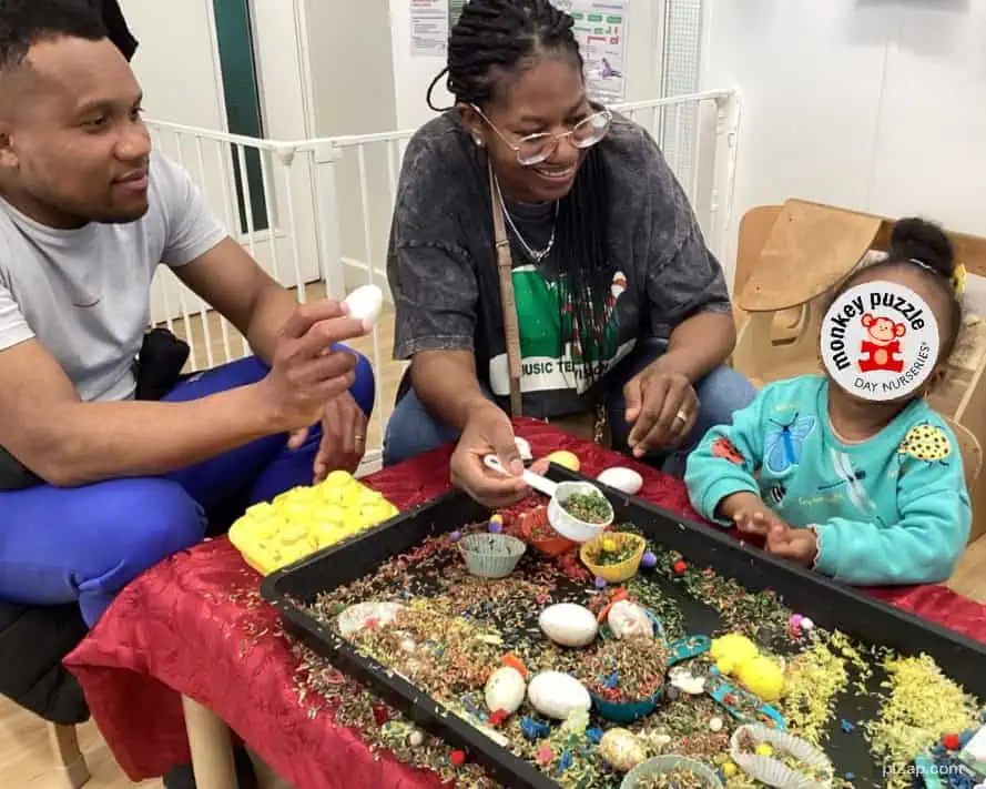 Colorful Easter egg decorating activity at Monkey Puzzle Day Nursery Enfield, featuring happy children and attentive staff in a welcoming nursery environment.