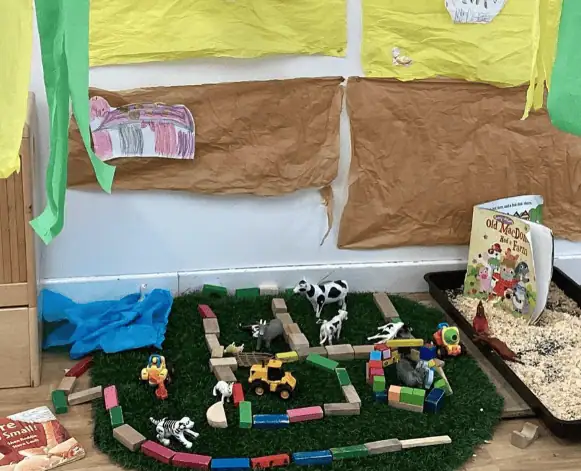 Building blocks toy farm play area with animal figurines and toy vehicles for preschool children at Monkey Puzzle Day Nursery Enfield.