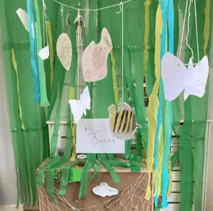 Colorful jungle-themed craft display at Monkey Puzzle Day Nursery Enfield with paper animals and green decorations for imaginative early childhood play.