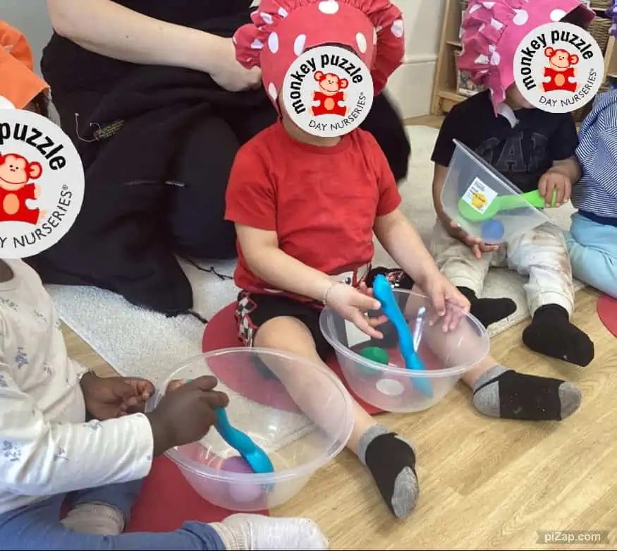 Monkey Puzzle Day Nursery Enfield children engaging in sensory play with colorful tools and toys.