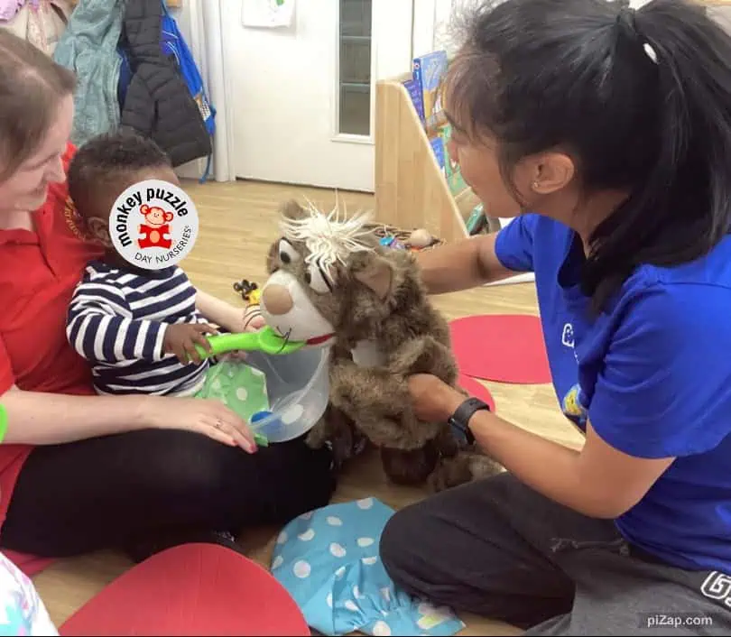 Soft play therapy with children and a plush lion toy at Monkey Puzzle Day Nursery Enfield, engaging children in imaginative and sensory activities for early childhood development.