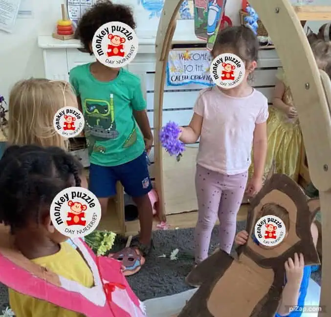 Monkey puzzle logo stickers over children's faces for privacy in a playful preschool setting.