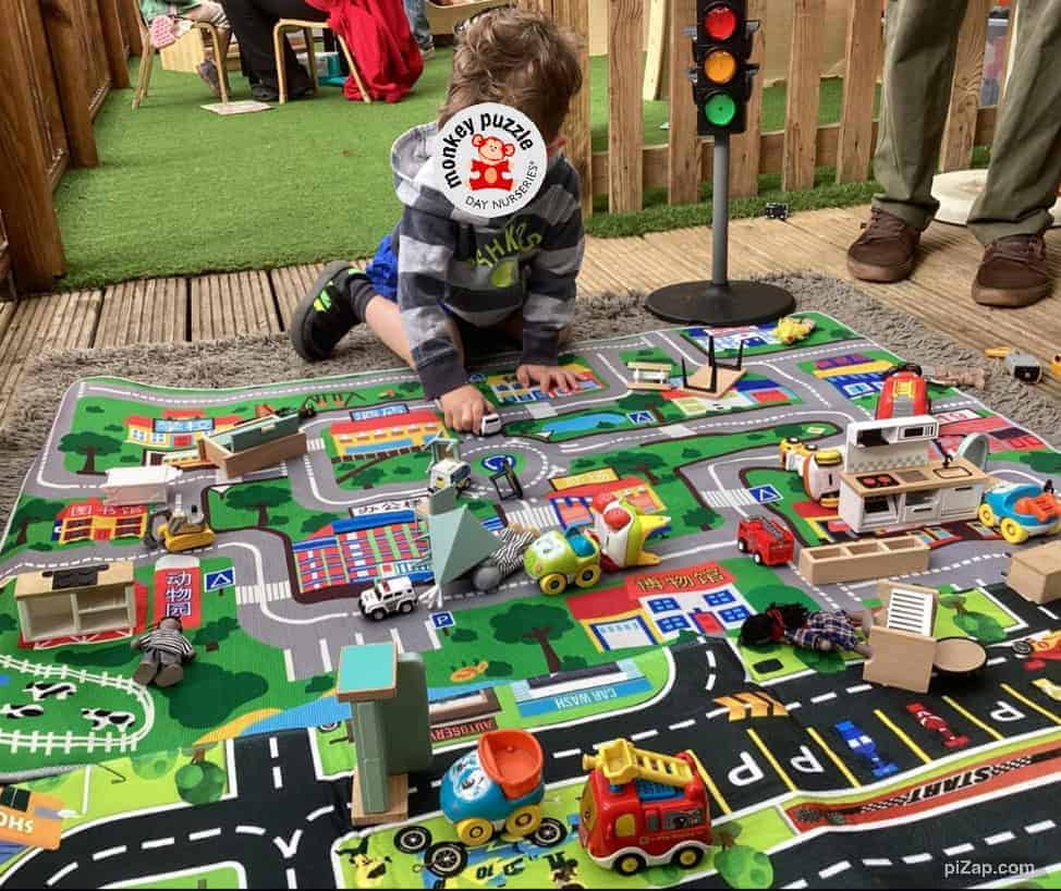 Colorful children's play area with toy cars, traffic light, and miniature buildings at Monkey Puzzle Day Nursery Enfield, suitable for early childhood development and imaginative play.