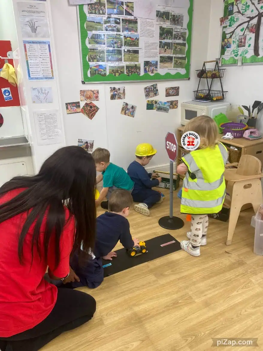 Childcare children playing with toy construction vehicles in a learning environment at Monkey Puzzle Day Nursery Enfield, engaging in imaginative play and early education activities.