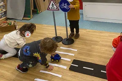 Children engaging in interactive traffic safety activity at Monkey Puzzle Day Nursery Enfield, fostering early learning and development.