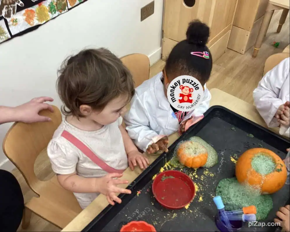 Pumpkin sensory play activity at Monkey Puzzle Day Nursery Enfield with young children exploring pumpkins and sensory materials.